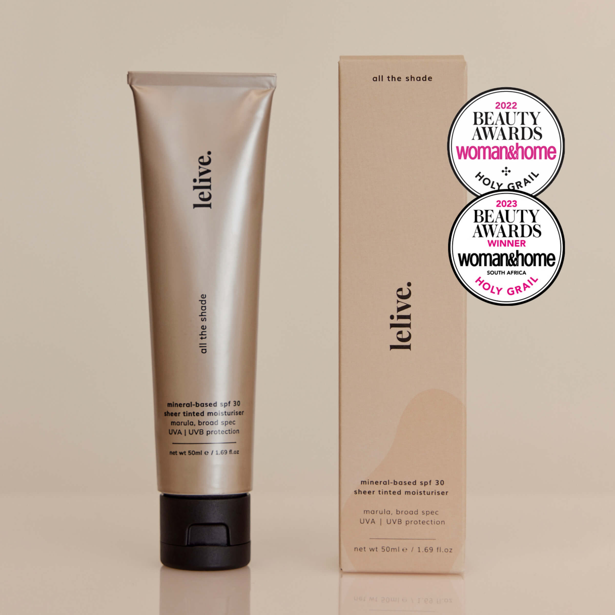 A tube of 'all the shade' SPF 30 sheer-tinted moisturizer next to its packaging box. The product has won several beauty awards, as indicated by the badges on the box.